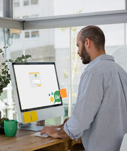 Hombre teclea frente a un monitor con la pantalla de inicio de sesión de Grup CIEF